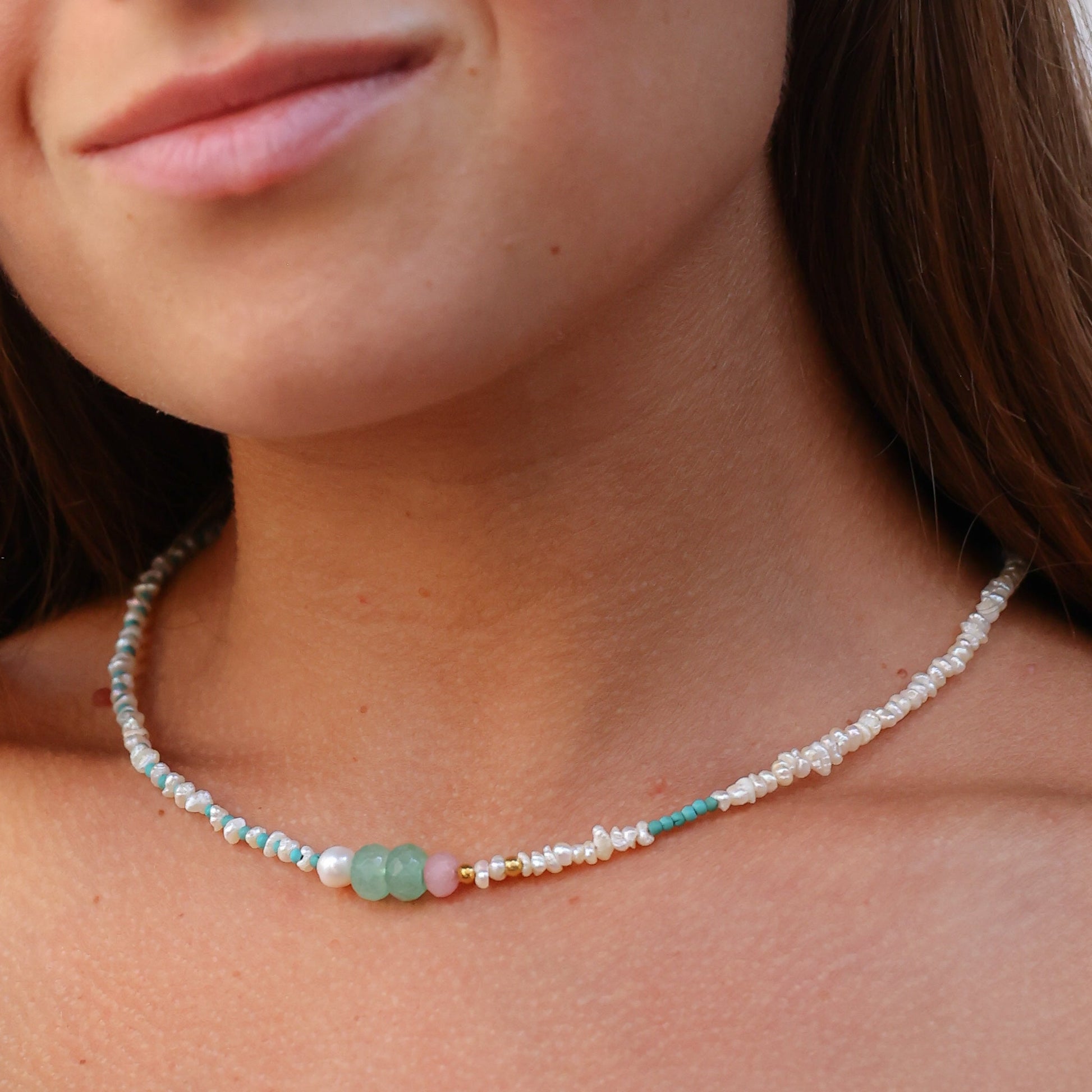 Close-up shot of a woman wearing an Andria Pearl & Turquoise Gemstone Necklace.