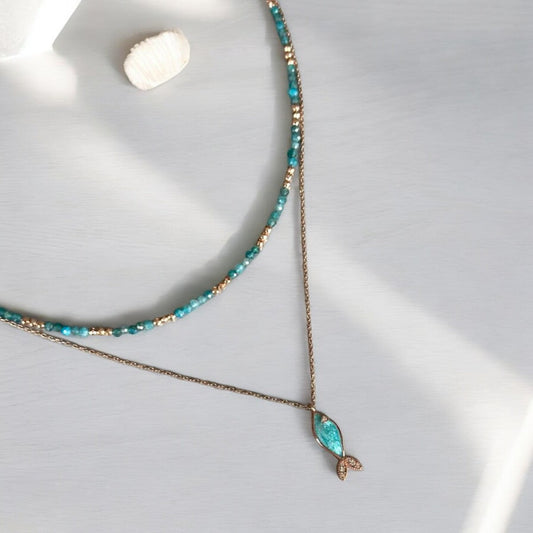 Azure Silver Fish Necklace paired with Apatite Gemstone Necklace on a light background with a seashell accent