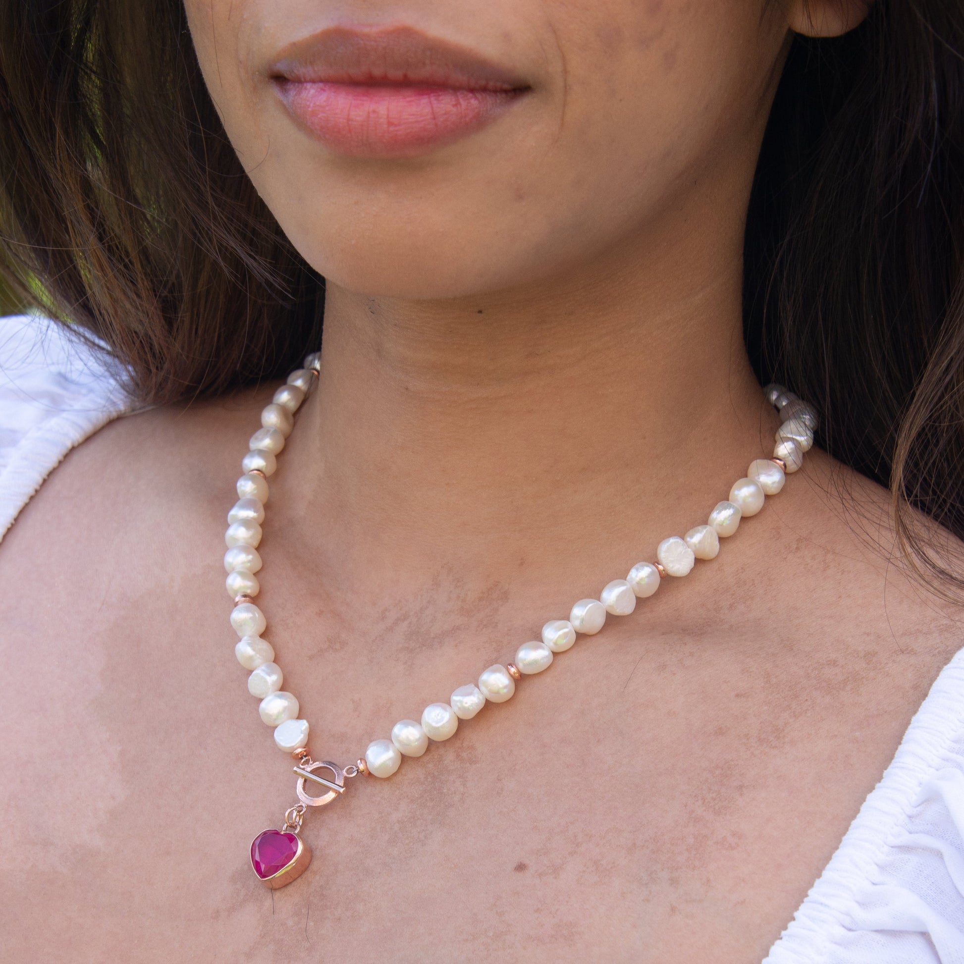 Woman wearing Baroque Pearl Heart Necklace with a pink heart pendant