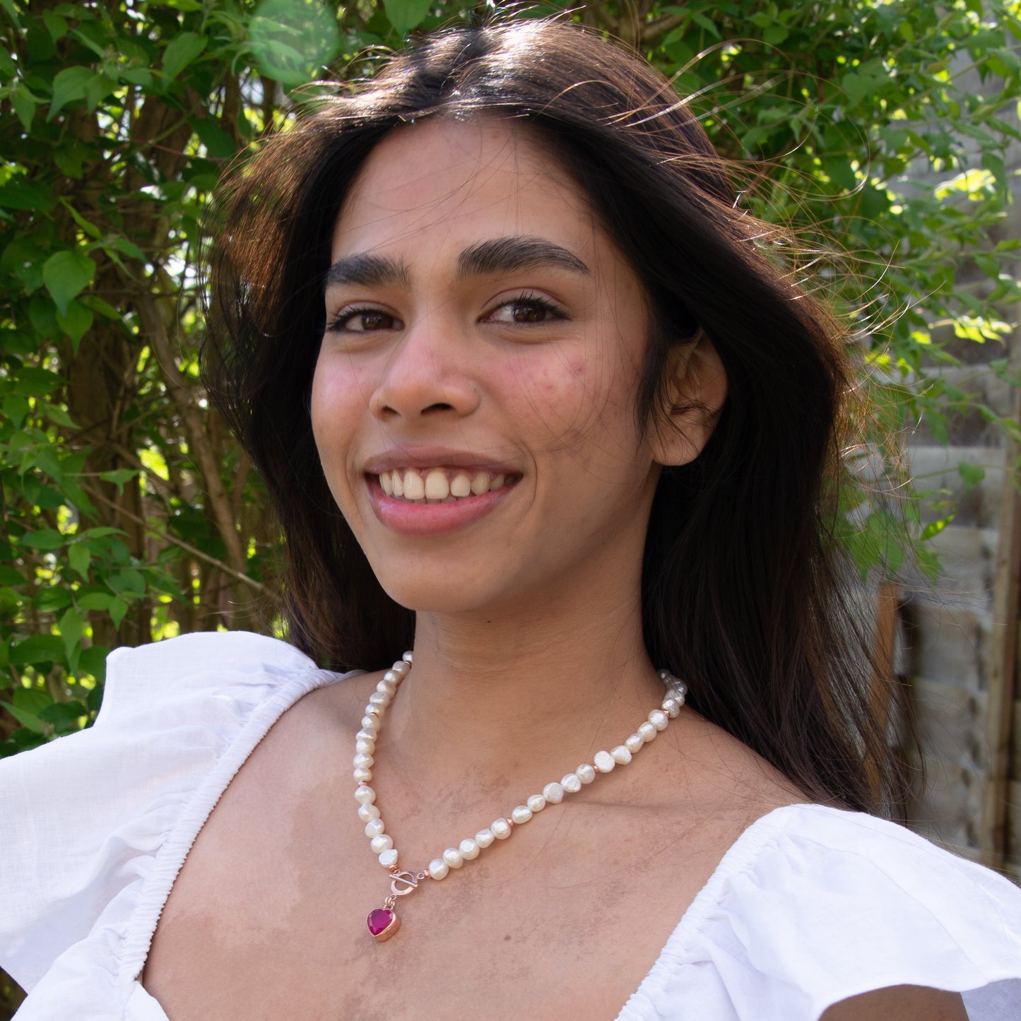 Woman Wearing Baroque Pearl Heart Necklace Outdoors