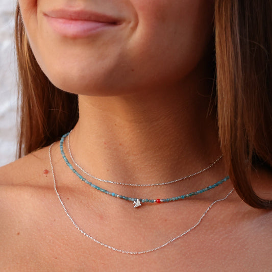 Close-up of woman wearing Birdie Minimal Silver Necklace with blue beads and delicate silver chain