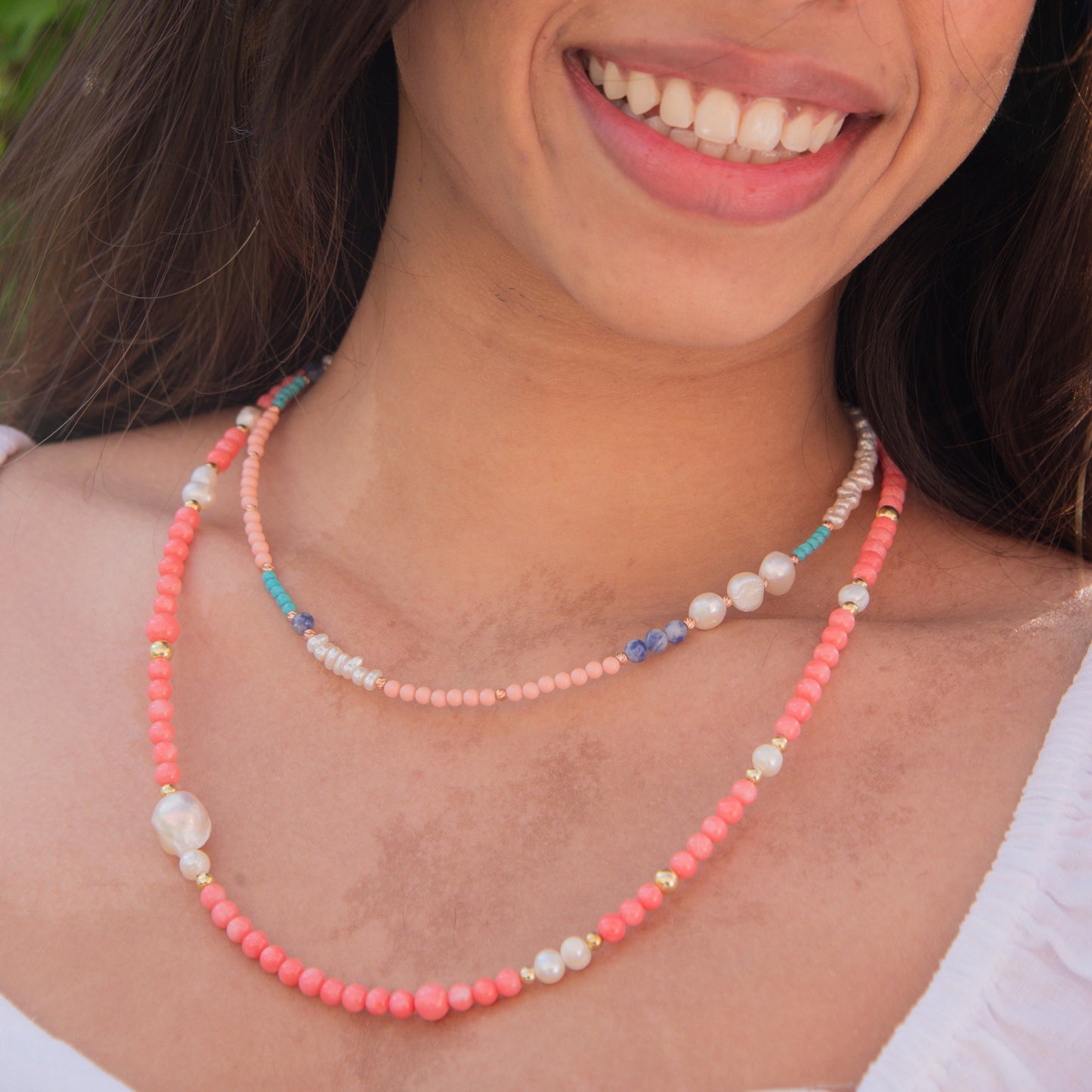 Smiling woman wearing Comiso Pearl and Gemstones Necklace with vibrant beads and pearls