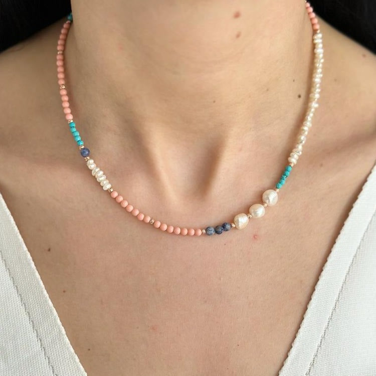 Comiso Pearl and Gemstones Necklace with coral, turquoise, and lapis beads worn by a woman