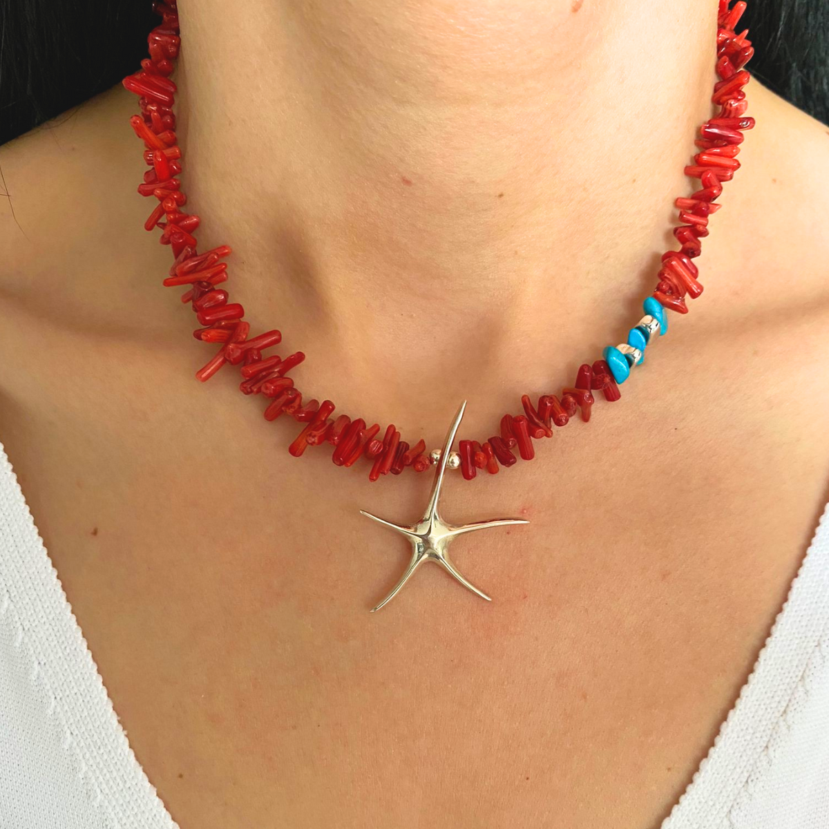 Close-up of Coral Starfish Necklace in 925 Silver on a female's neck - Handmade Elegance