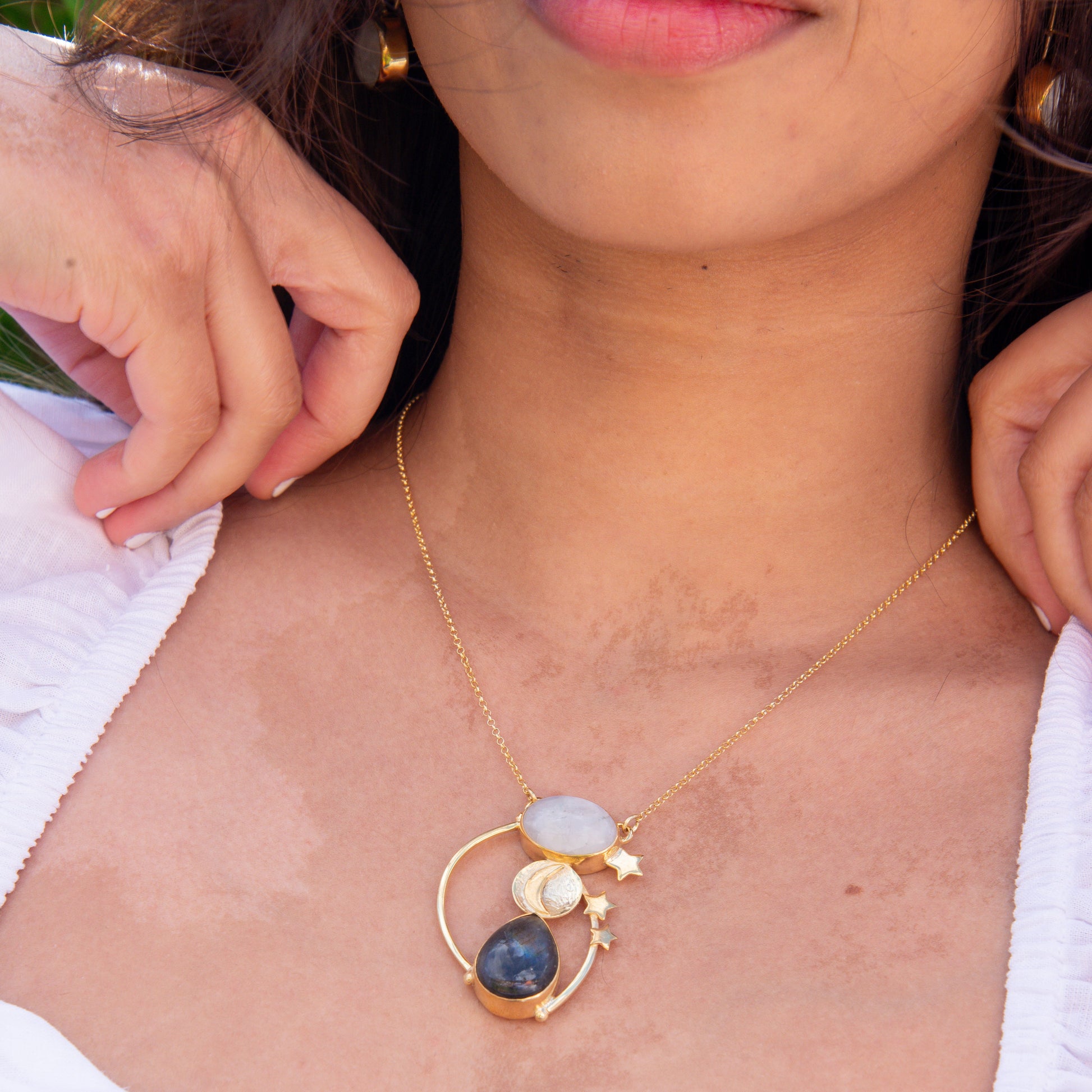 Woman wearing a Day and Night Moonstone Silver Necklace with celestial design featuring sun, moon, and stars.