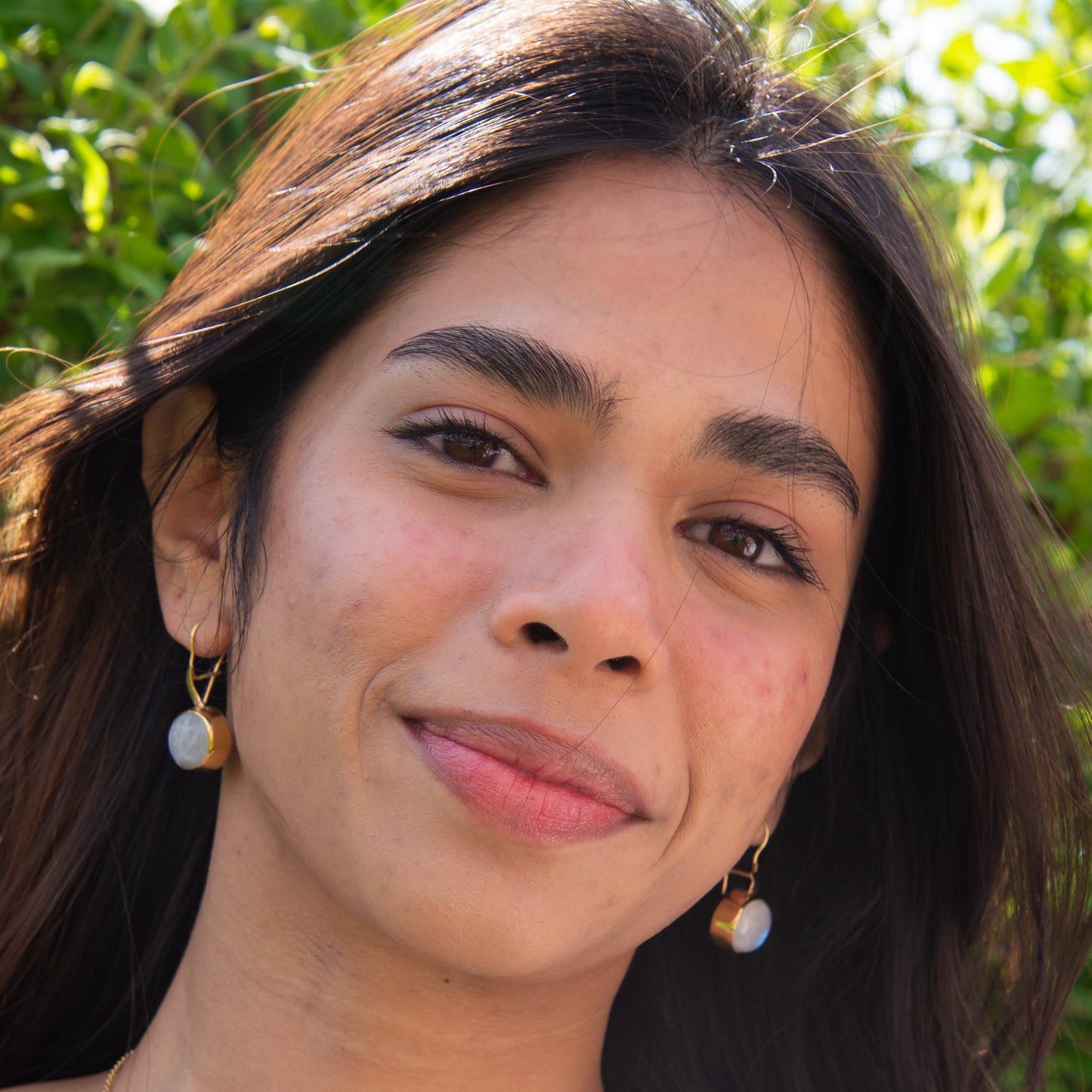 Woman wearing Day and Night Moonstone Silver Necklace with matching earrings.