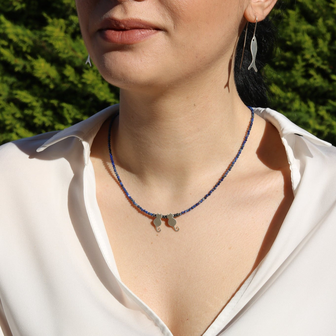 Woman wearing Duo Cats Lapis Silver Necklace with blue beads and cat-shaped silver pendants