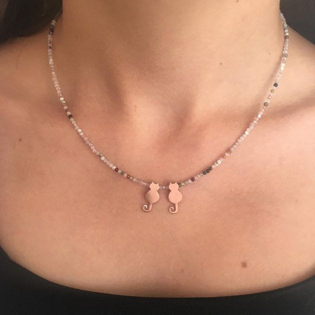 Close-up of Duo Mini Cats Silver Necklace worn on a woman's neck.