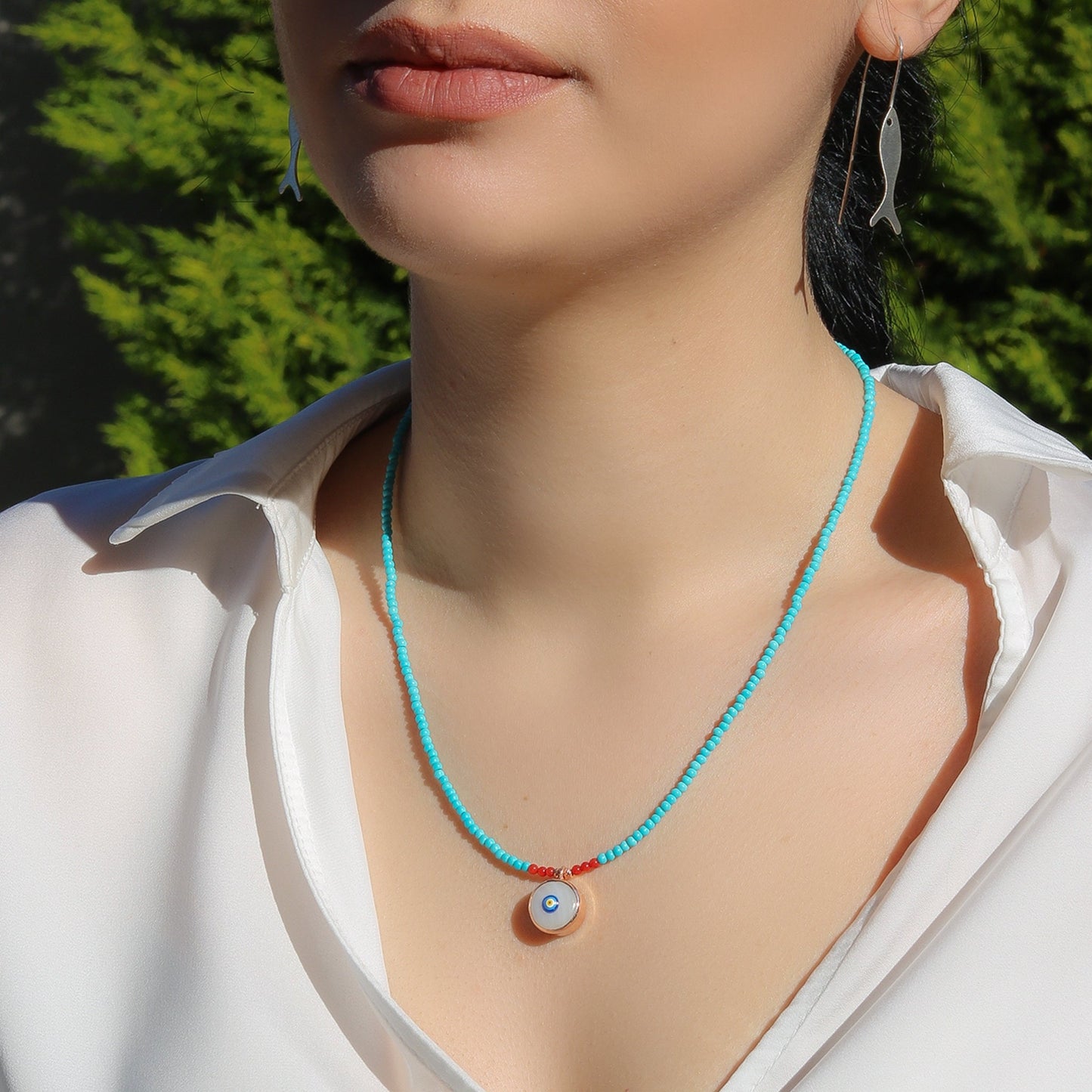 Evil Eye Howlite Beaded Necklace worn by a woman in a white shirt