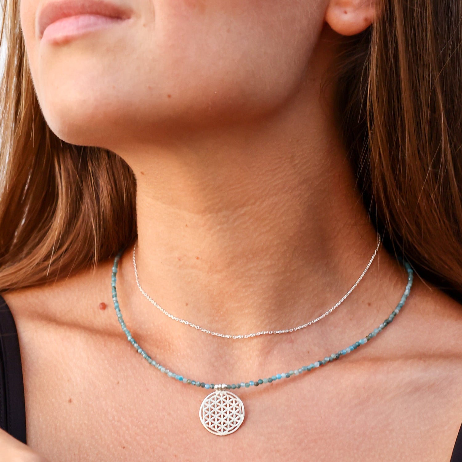 Woman wearing Flower of Life Apatite Necklace with silver chain and gemstone beads