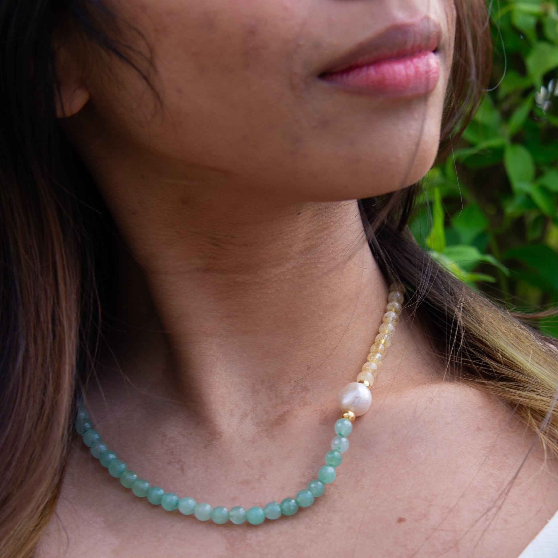 Foligna Aventurine and Citrine Gemstone Beaded Necklace worn by a model, featuring a combination of green and yellow beads with a central pearl accent.