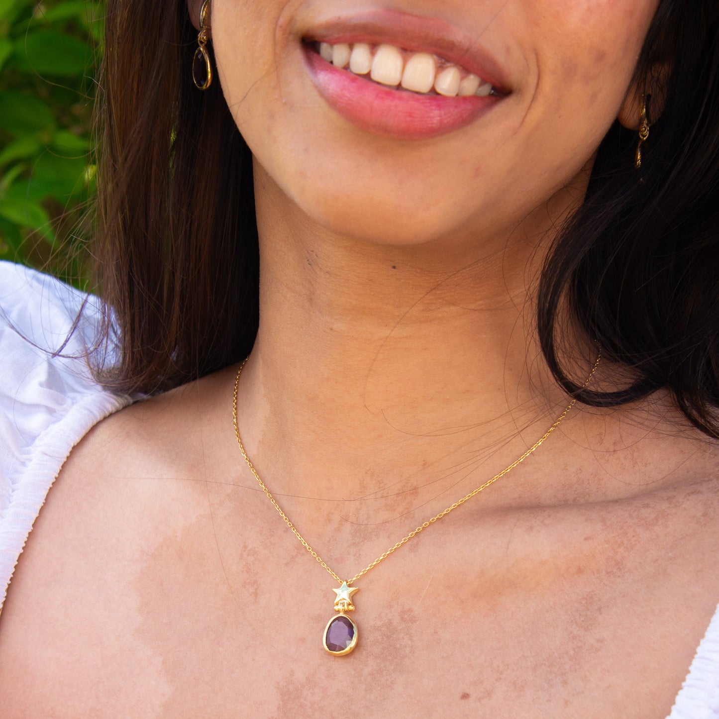 Foligno Purple Cat's Eye Stone Silver Chain Necklace and Earrings Set modeled by a woman wearing white attire.