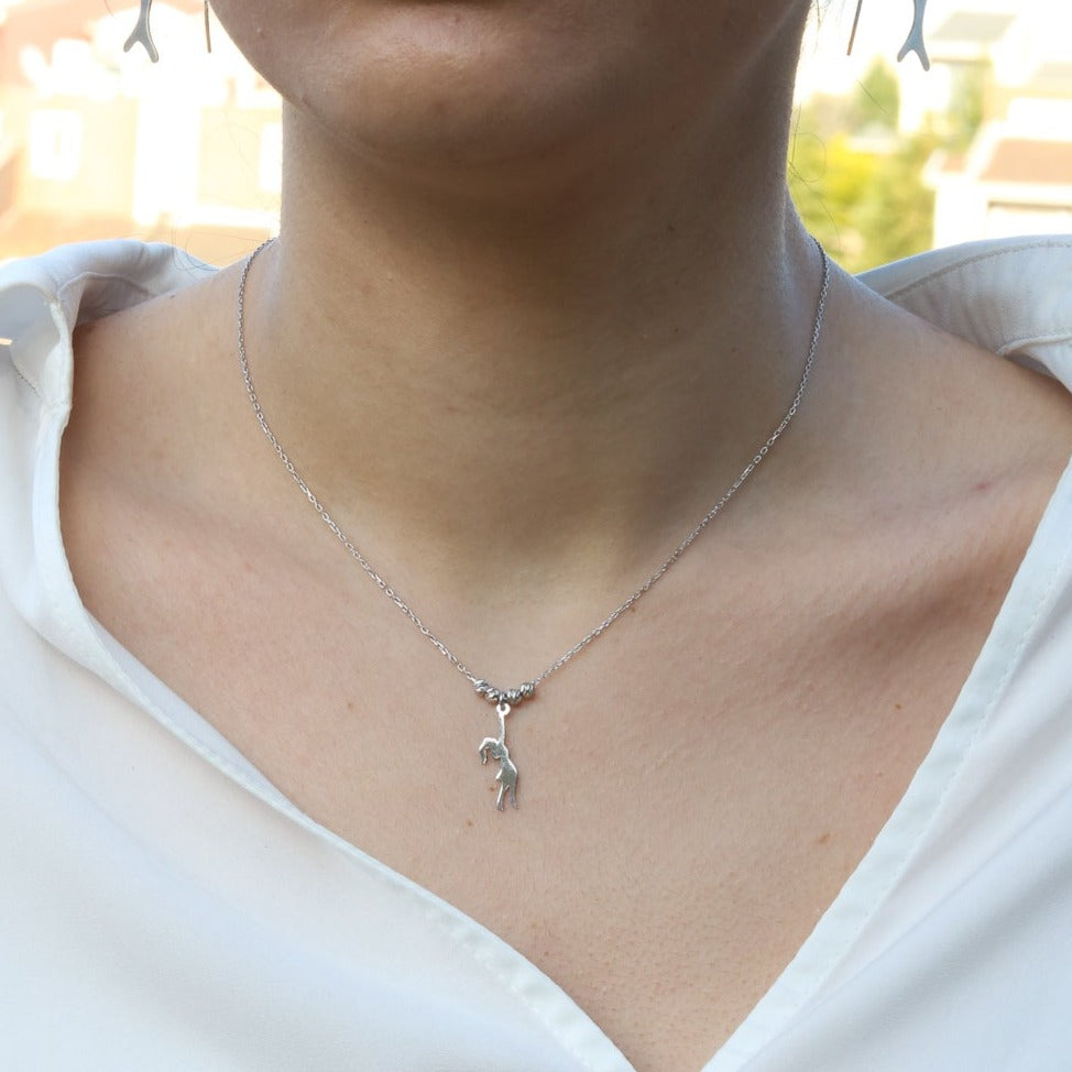 Girl with Balloons Silver Necklace worn by a woman in a white blouse