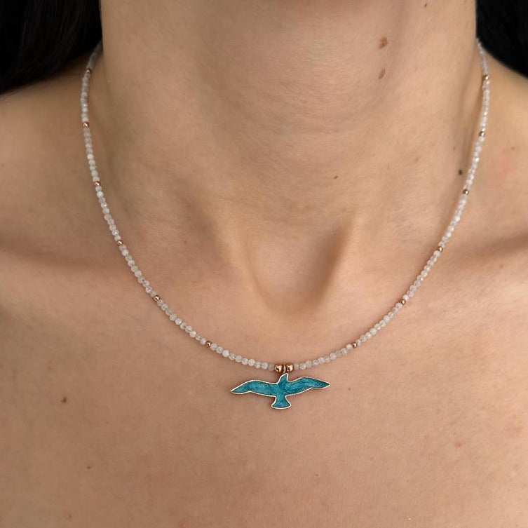 Woman wearing Istanbul Moonstone Seagull Necklace on a delicate moonstone bead chain.