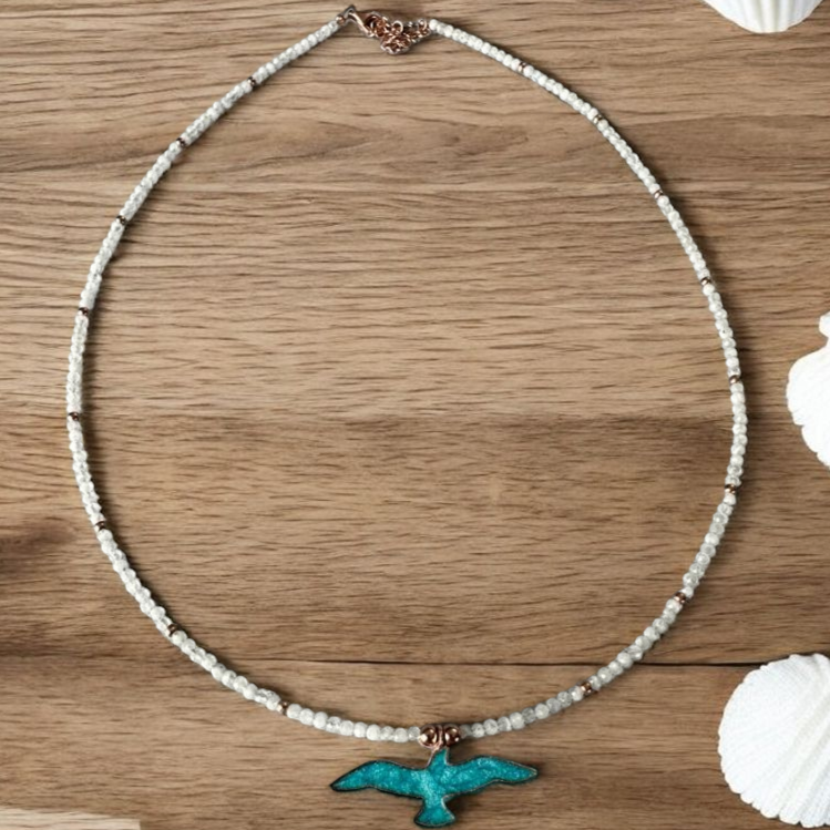 Istanbul Moonstone Seagull Necklace with turquoise seagull pendant on wooden background.