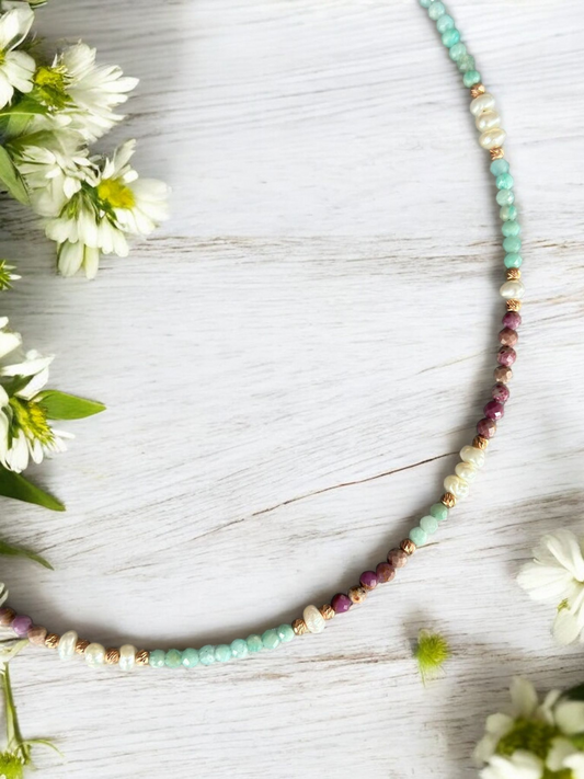 Lilith Gemstone Necklace featuring Lepidolite, Amazonite, and Freshwater Pearls displayed with white flowers