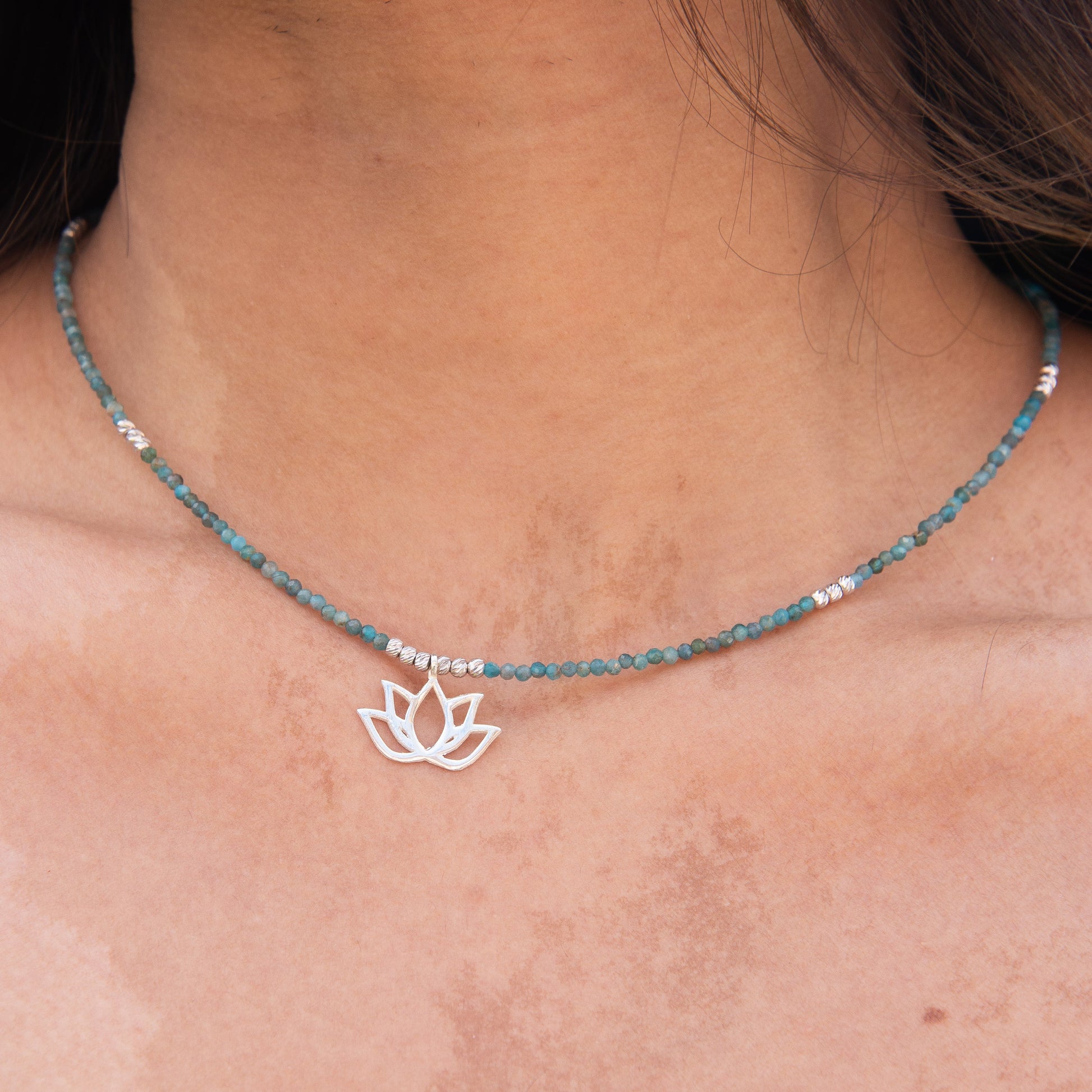 Elegant Lotus Flower Apatite Necklace on a woman's neck, featuring a silver lotus pendant and blue apatite beads.