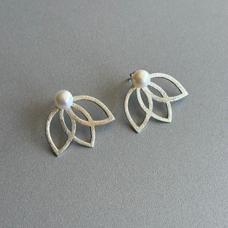 Lotus Flower Silver and Freshwater Pearl Earrings on a grey background