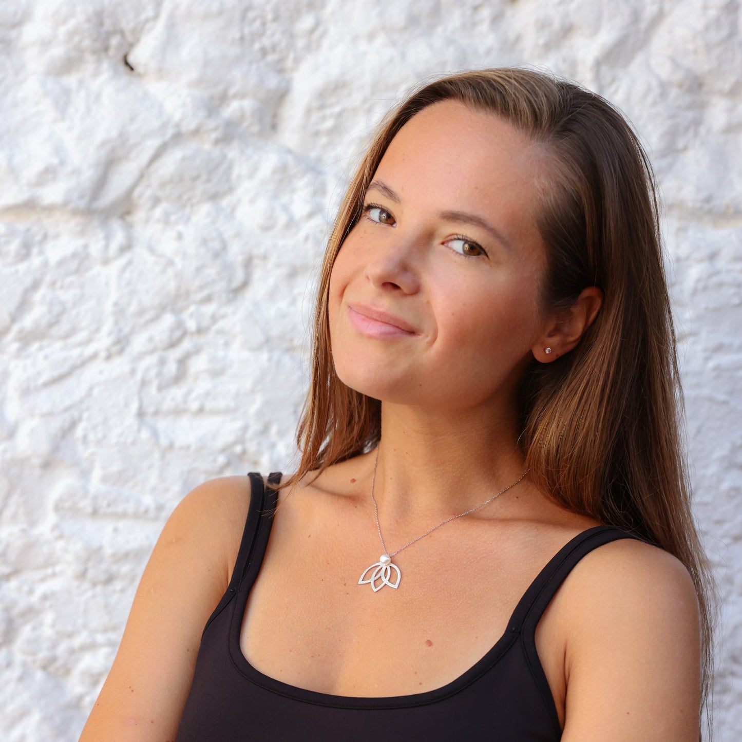 Woman wearing Lotus Flower Silver and Pearl Necklace against white background