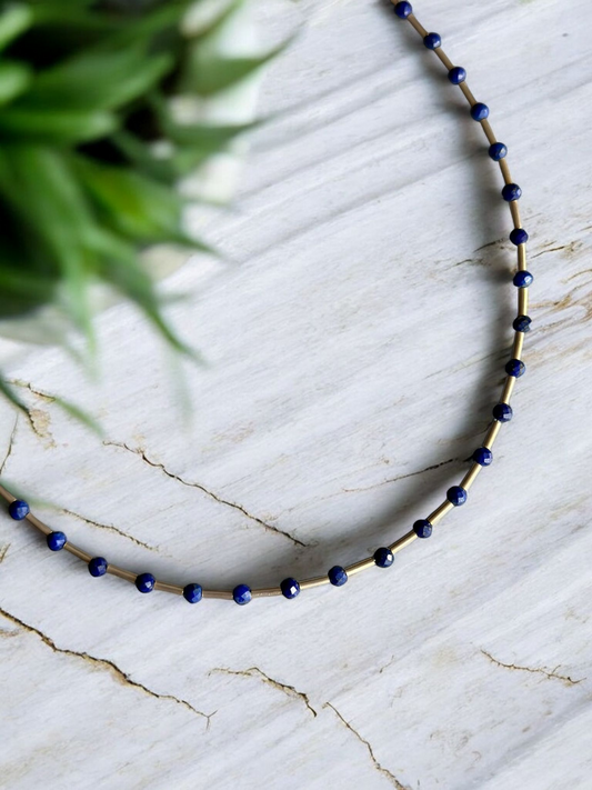 Melia Lapis Lazuli Gemstone and Silver Necklace with blue beads and silver spacers on a marble background