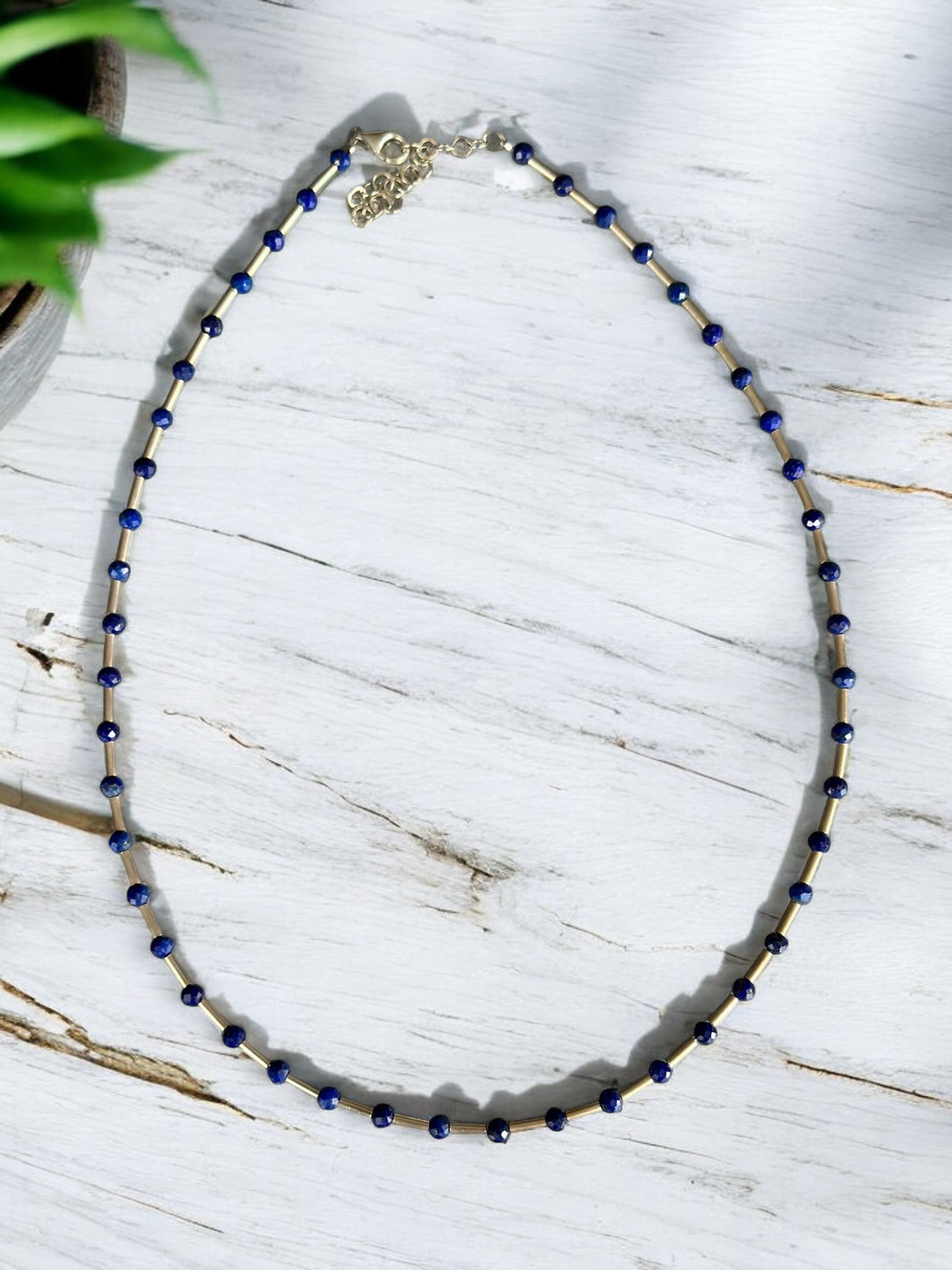 Melia Lapis Lazuli Gemstone and Silver Necklace on a white wooden background