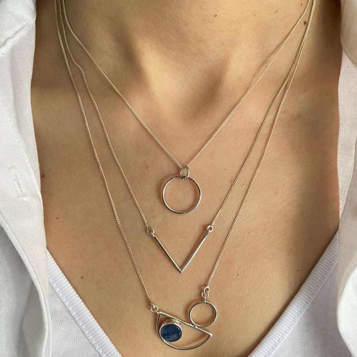 Woman wearing Messina Layered Silver Necklace Set with three distinct geometric pendants