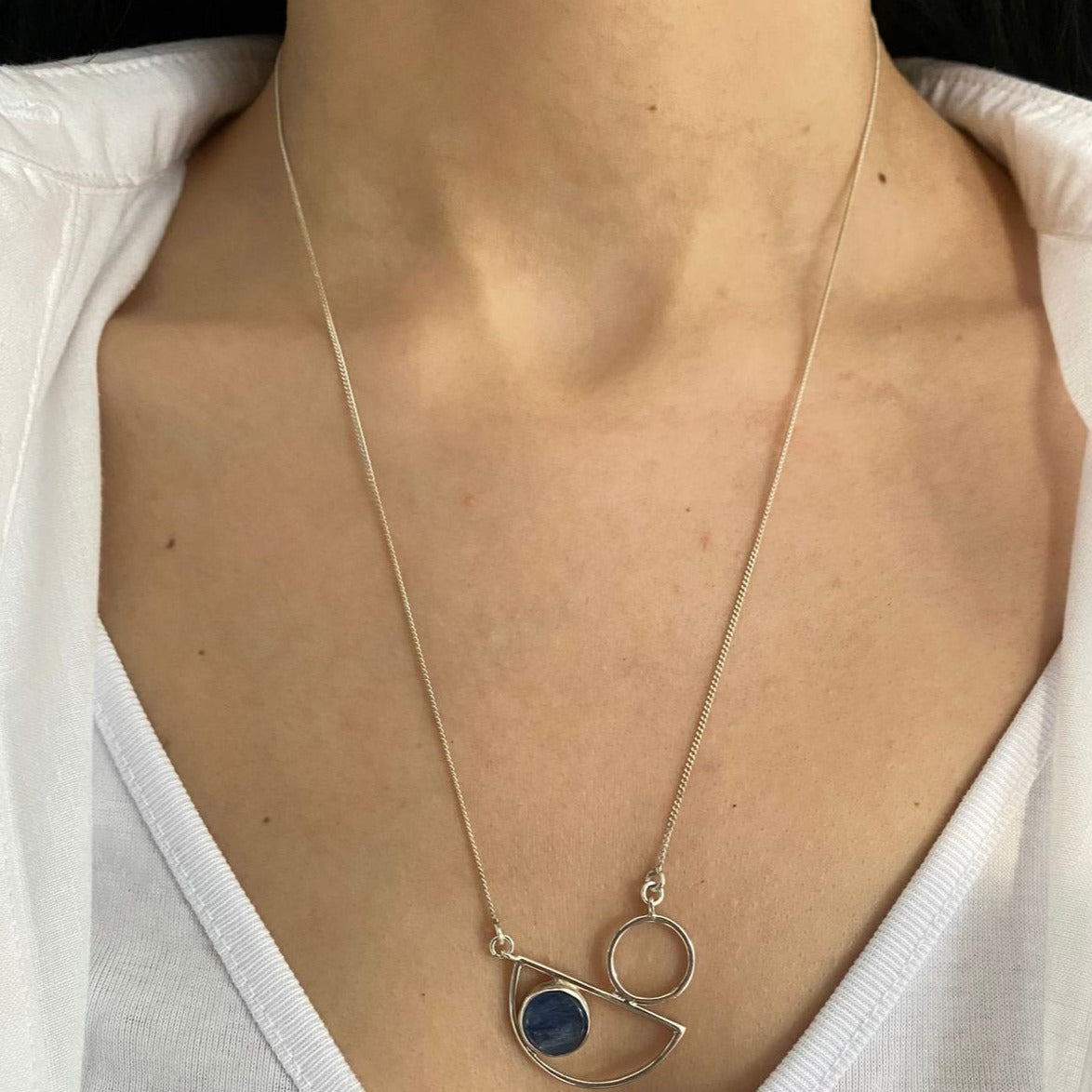 Messina Layered Silver Necklace Set featuring geometric design with blue stone, worn by a model.