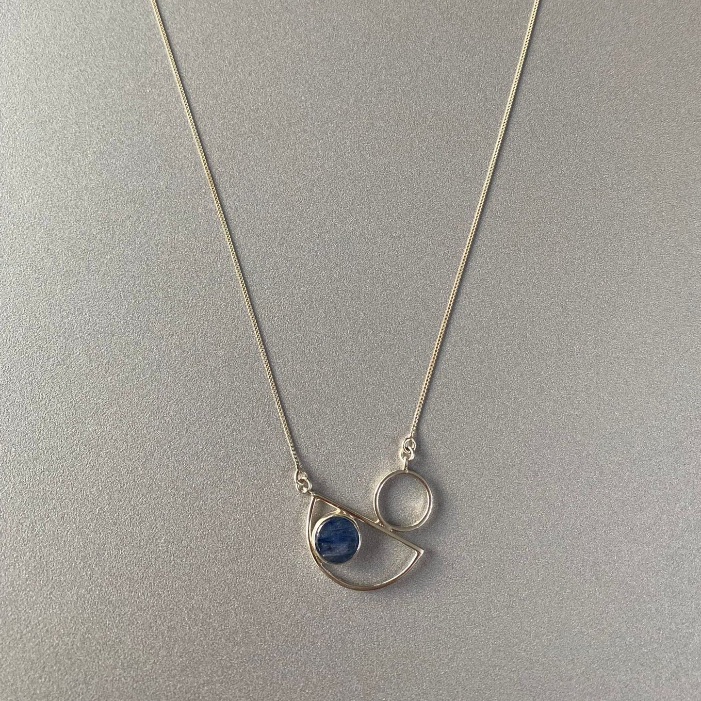 Messina Layered Silver Necklace Set featuring geometric pendants with a blue stone accent on a silver chain.