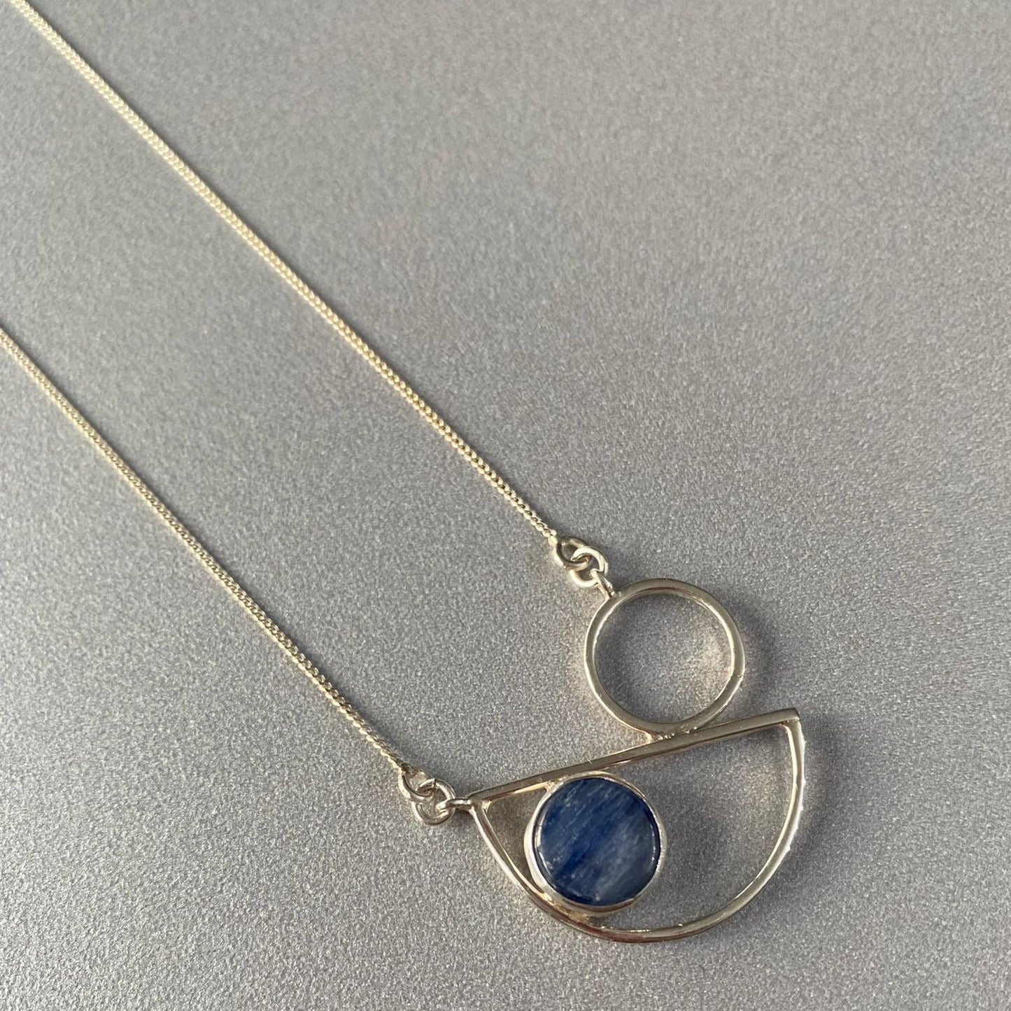 Messina Layered Silver Necklace Set featuring geometric silver pendant with blue stone accent on a sleek chain.