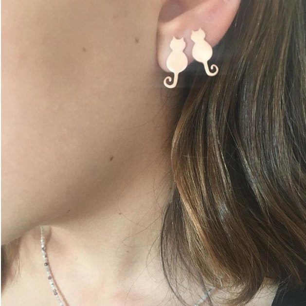 Close-up of a woman's ear wearing Mini Cat Silver Earrings with a cute cat design.