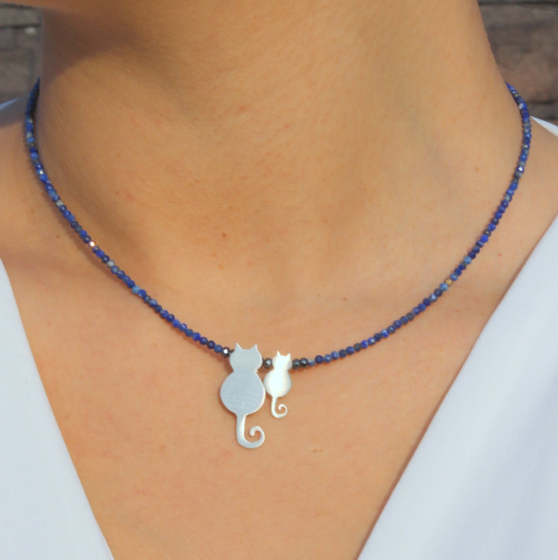 Mother Cat and Kitten Silver Necklace on a person's neck with blue beaded chain