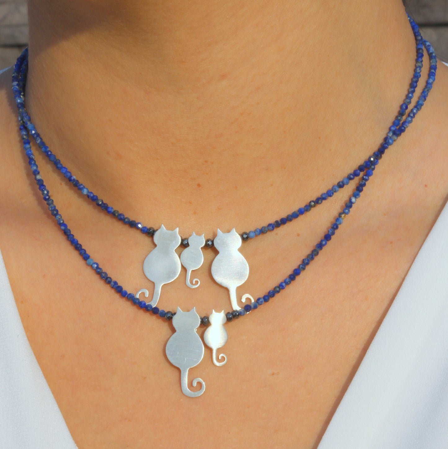 Mother Cat and Kitten Silver Necklace on a model's neck with blue beaded chain