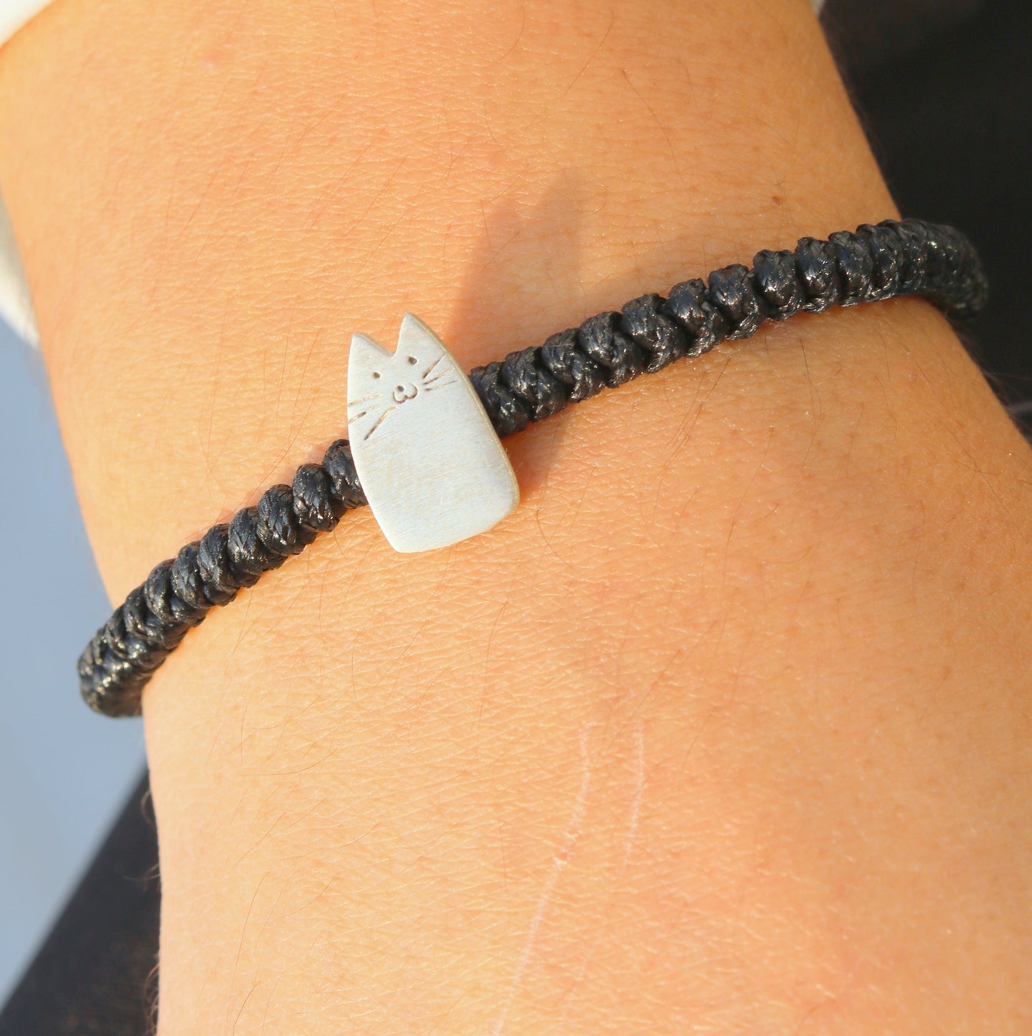 Close-up of My Kitten Friend Silver Black Bracelet featuring a cute silver kitten charm on a black braided band.