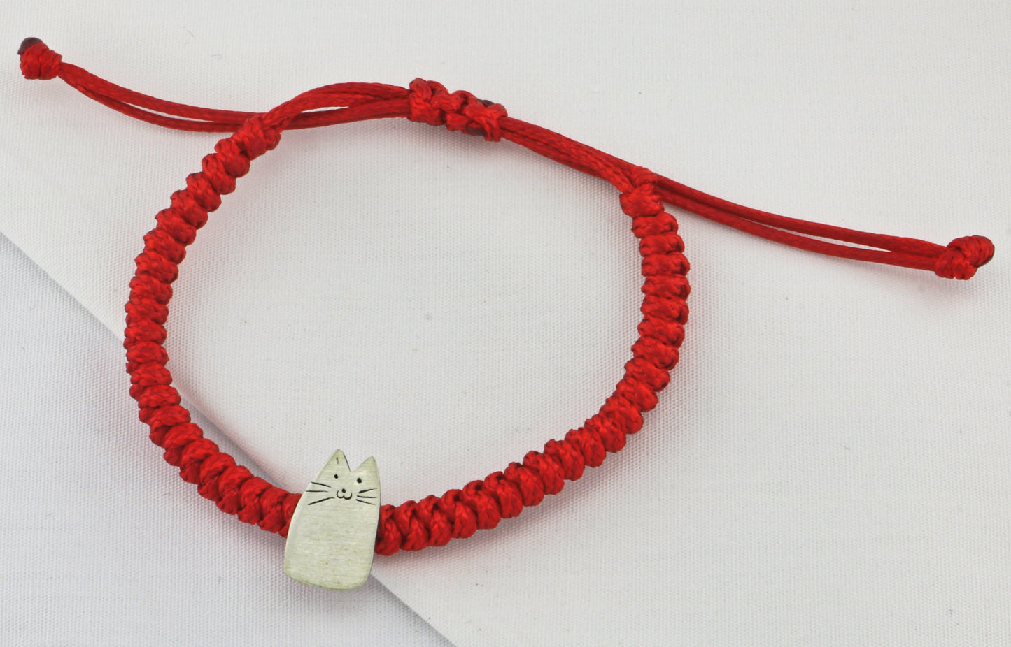 My Kitten Friend Silver Red Bracelet featuring a handcrafted silver cat charm on a red braided cord.