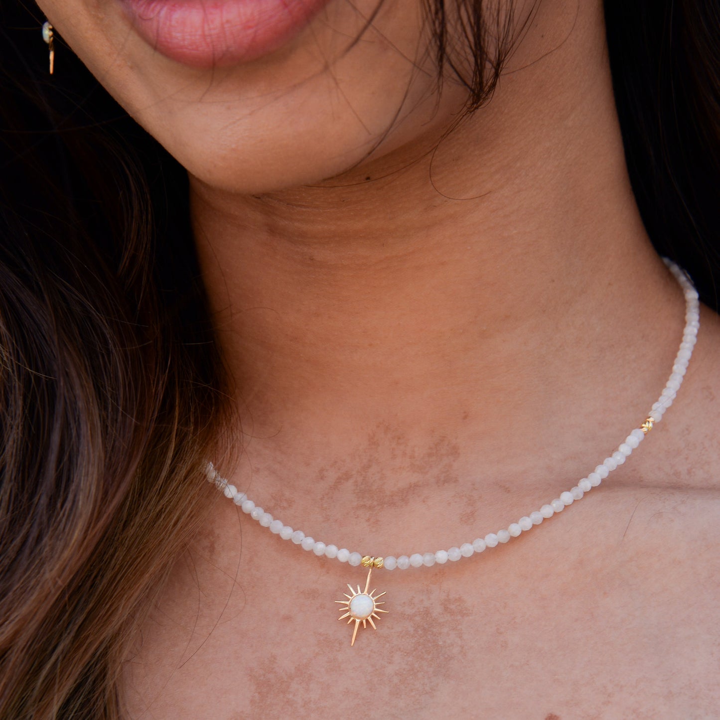 Close-up of woman wearing North Star Moonstone Necklace with a radiant star charm