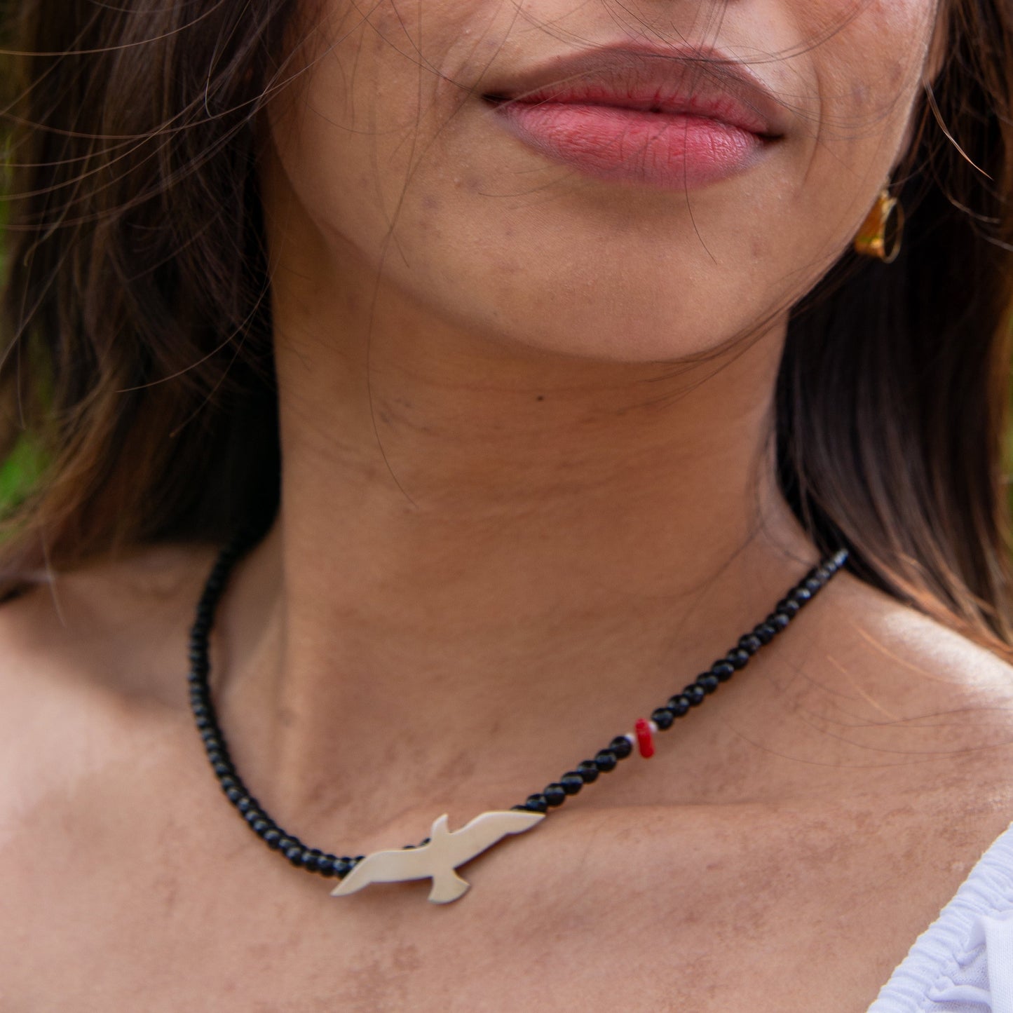 Woman wearing Onyx Seagull and Red Bead Silver Necklace