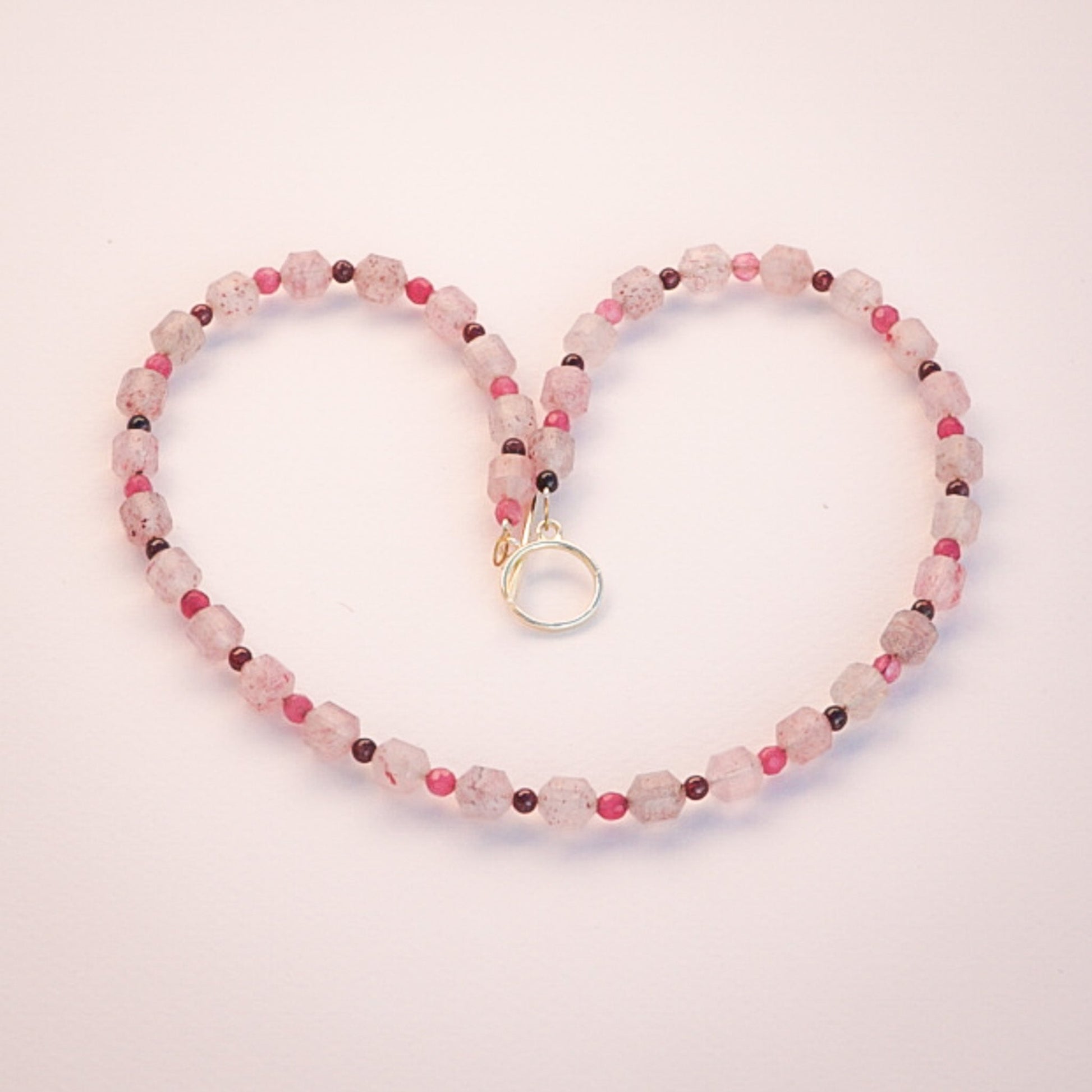 Pinky Strawberry Quartz Gemstone Necklace with faceted beads and a gold clasp.