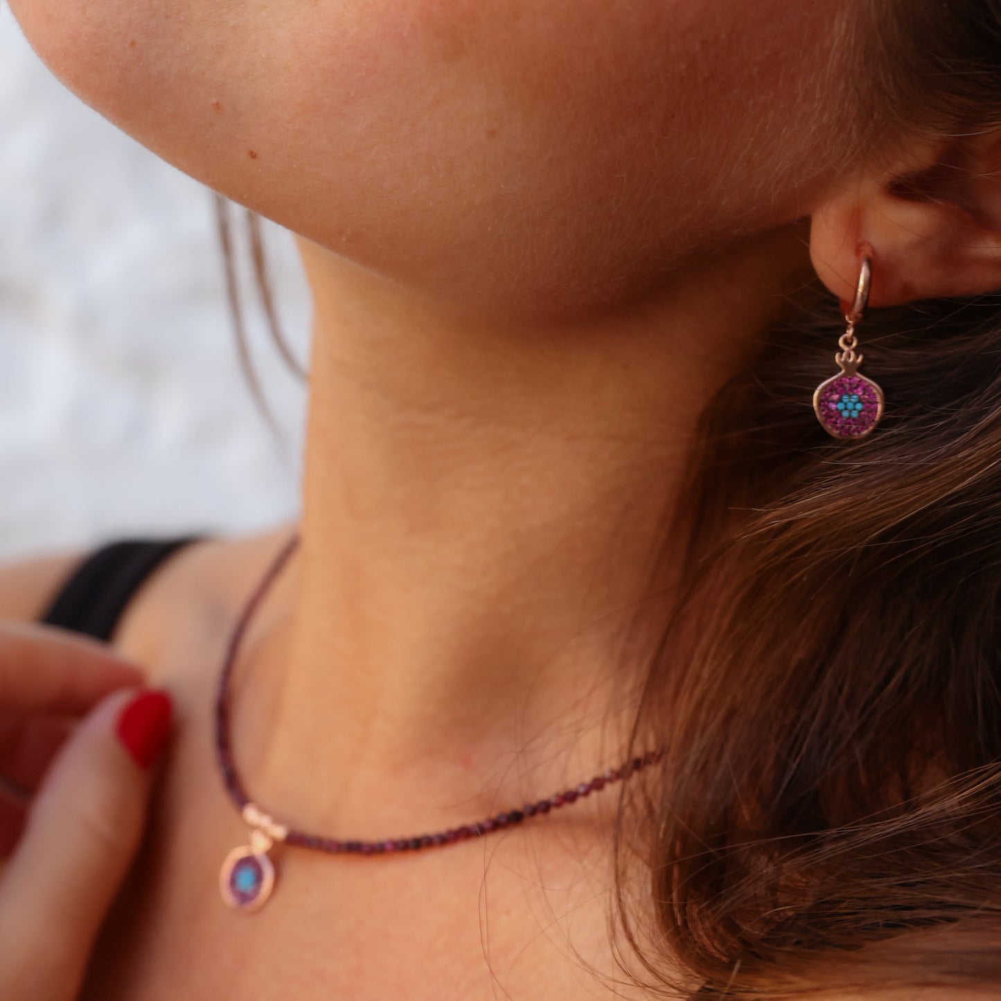 Woman wearing Pomegranate Garnet Earrings with a matching necklace.