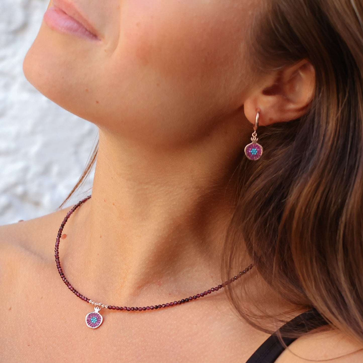 Woman wearing Pomegranate Garnet Earrings and matching necklace