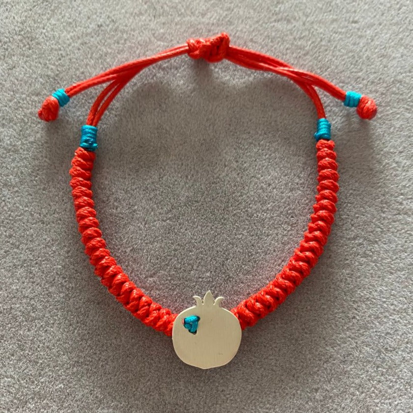 Vibrant red pomegranate silver bracelet with blue accents and adjustable knot