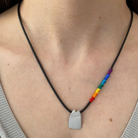 Rainbow Cutie Cat Silver Cord Necklace on a person's neck, featuring a cat-shaped silver pendant and rainbow-colored cord accents.