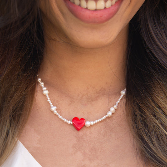 Rojo Natural Freshwater Pearl Necklace with a Red Glass Heart Pendant worn by a smiling woman