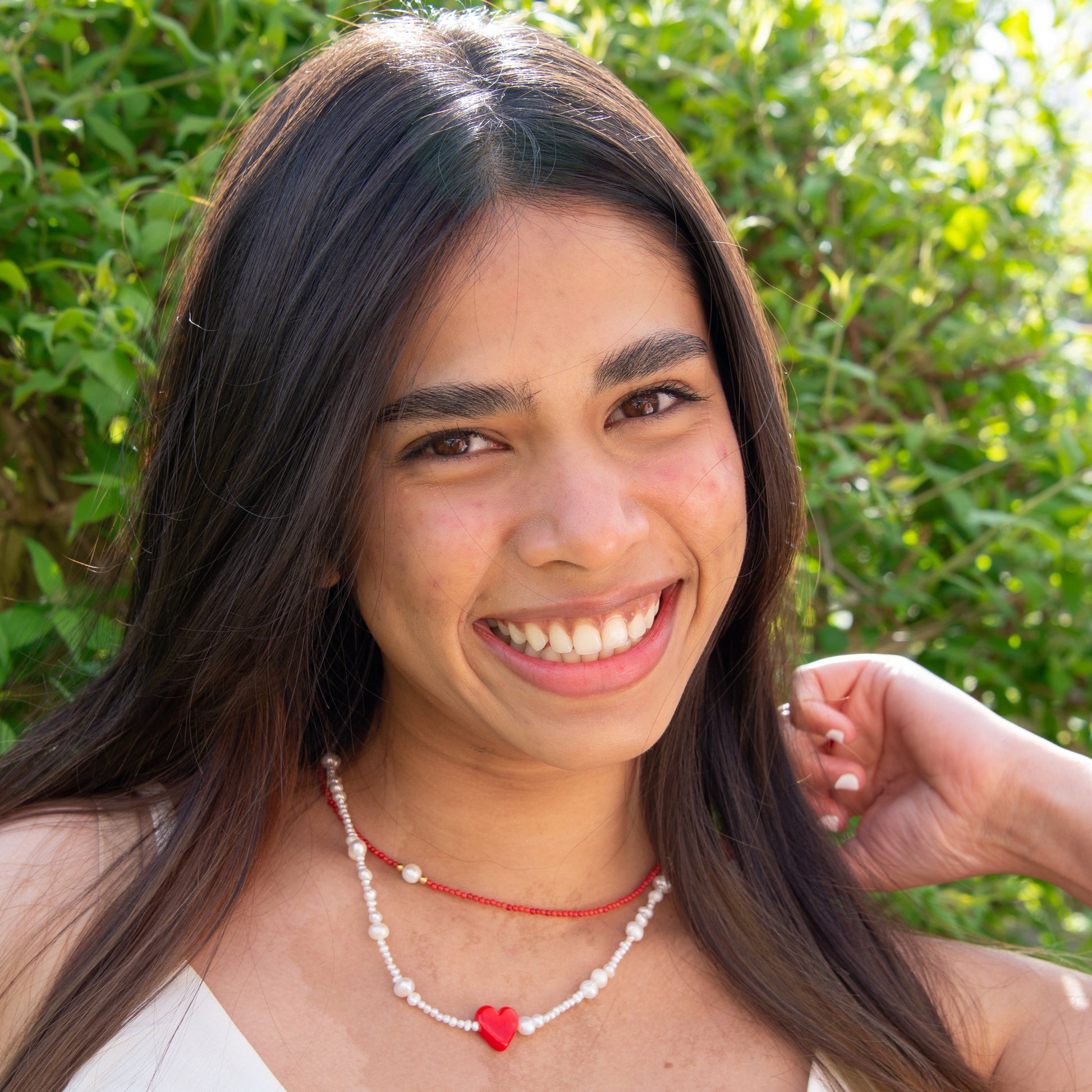 Woman wearing Rojo Natural Freshwater Pearl Necklace with Red Glass Heart Pendant