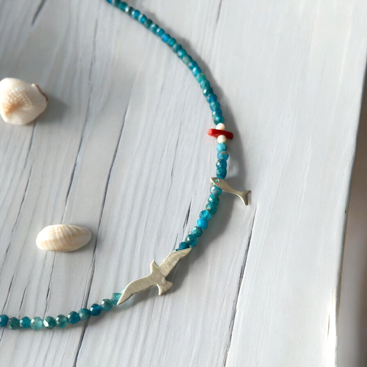 Seagull & Fish Apatite Gemstone Necklace - 925 Silver on wood surface with seashells