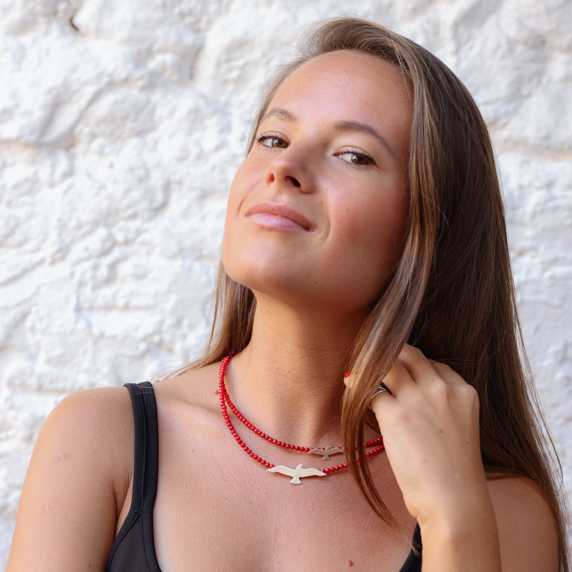 Woman wearing Seagulls Coral Silver Necklace with red beads and silver bird pendants