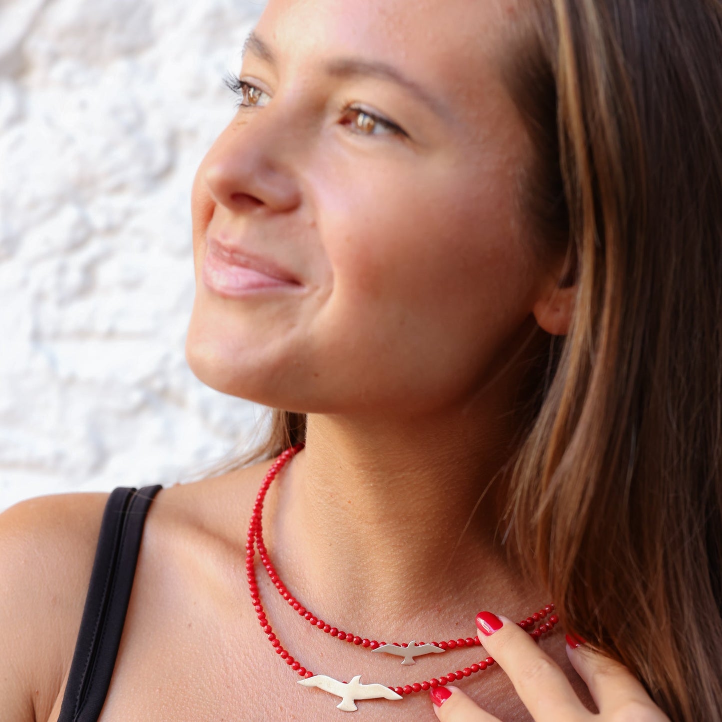 Woman wearing Seagulls Coral Silver Necklace with red beads and silver bird pendants.