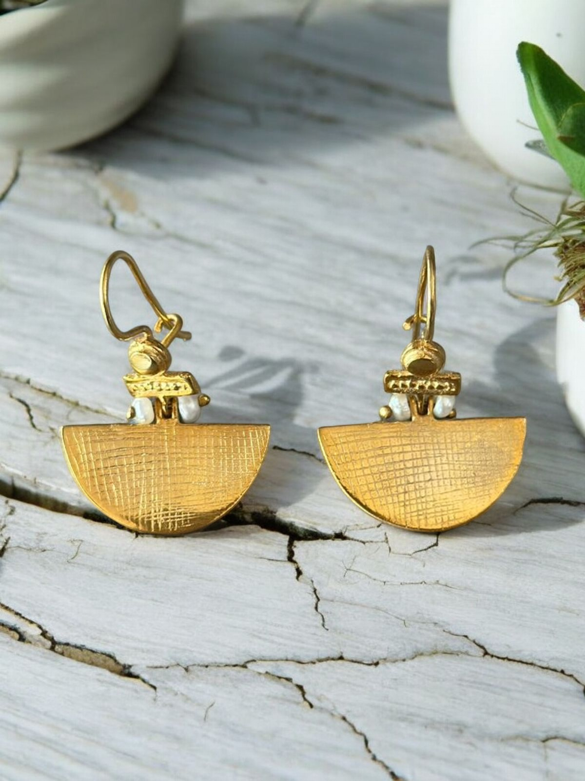 Selena Gold Plated Silver Earrings with geometric half-moon design on a wooden surface.