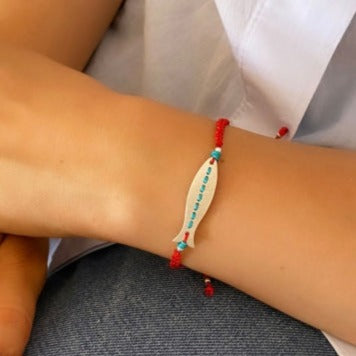 Hand wearing Skinny Fish Silver Bracelet with red and turquoise accents