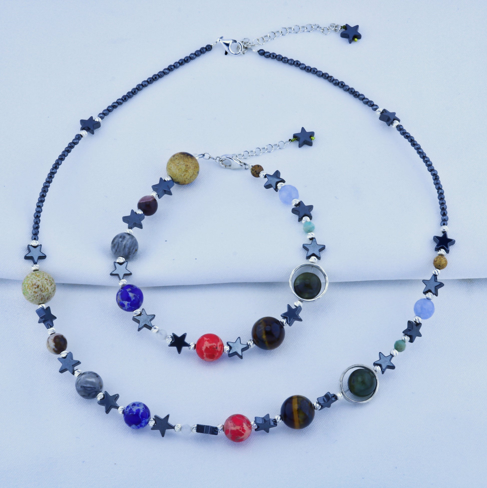 Solar System Necklace and Bracelet Set featuring colorful planetary beads and star accents on a white background.