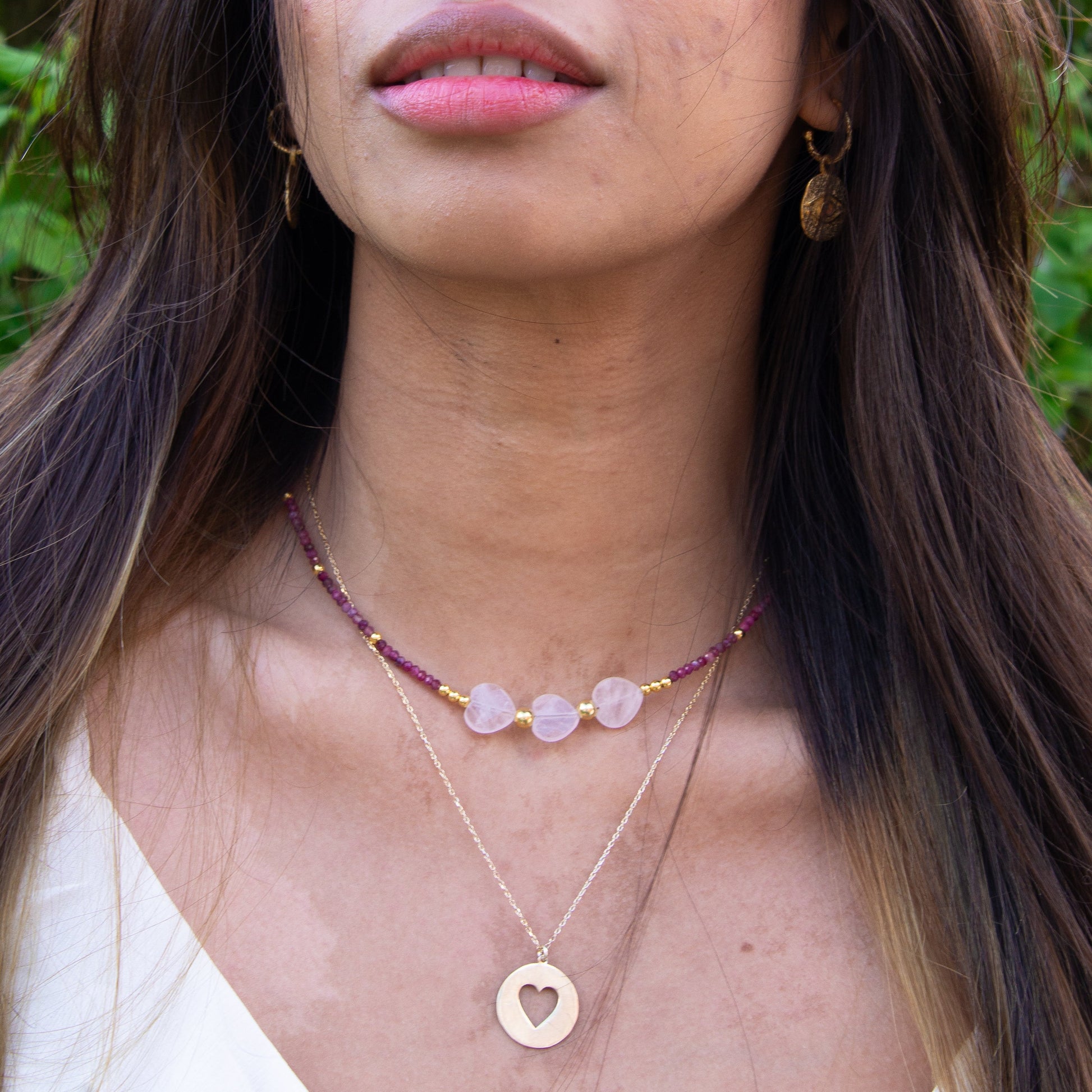 Woman wearing Three Hearts Tourmaline Gemstone Beaded Necklace with heart-shaped pendants and gold accents.